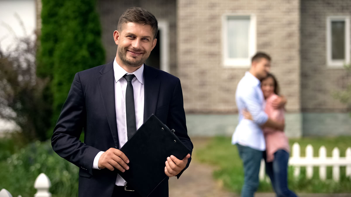 Realitní makléř realitní kanceláře Relia na prohlídce domu k prodeji s párem zákazníků, který má o dům zájem.